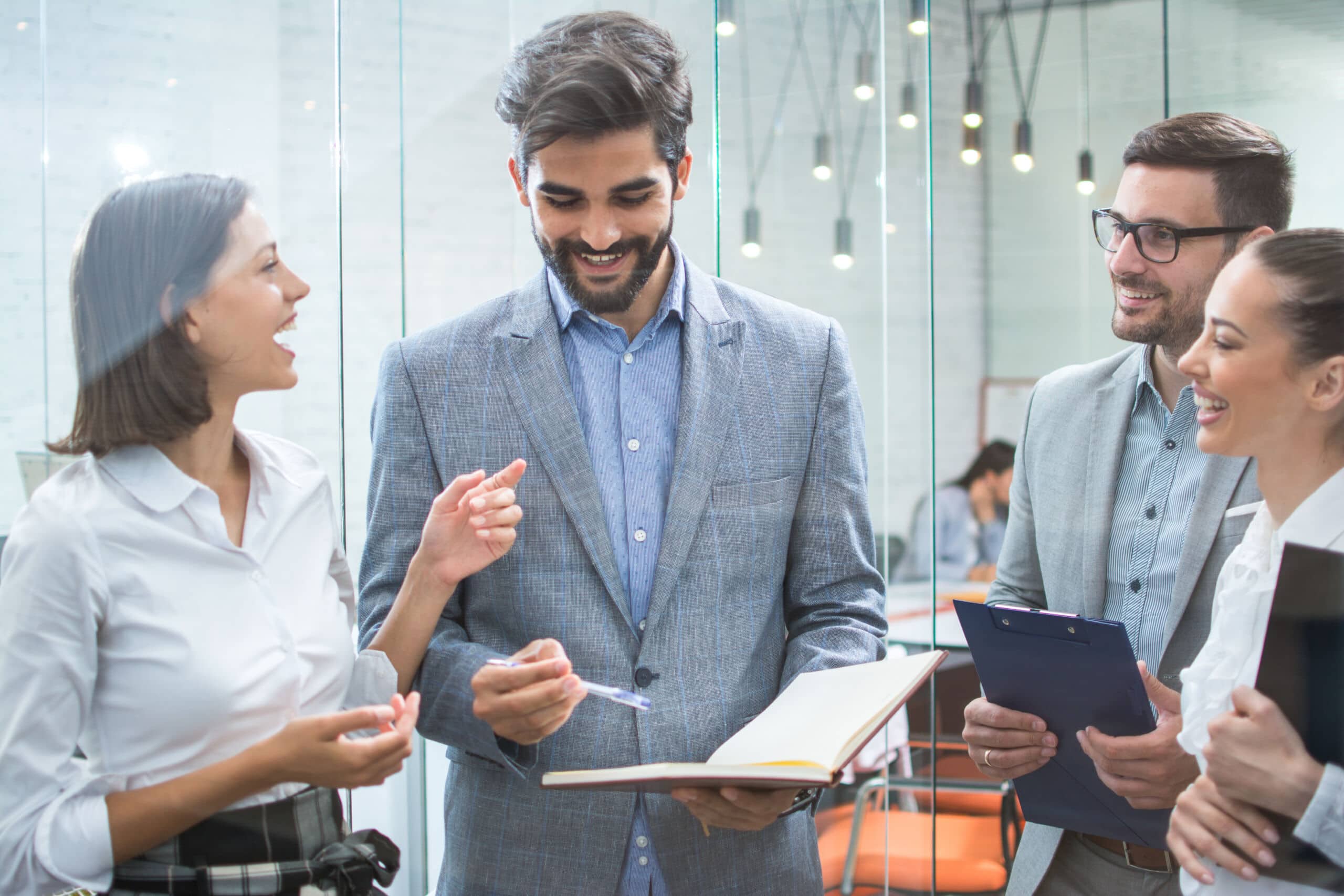 Business team discussing business documents, standing in the office lobby